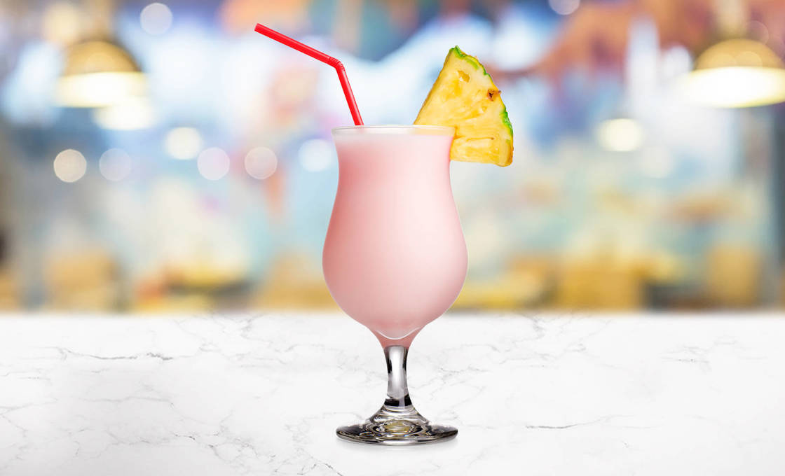 Glass of Lime & Pink Grapefruit Smoothie garnished with pineapple