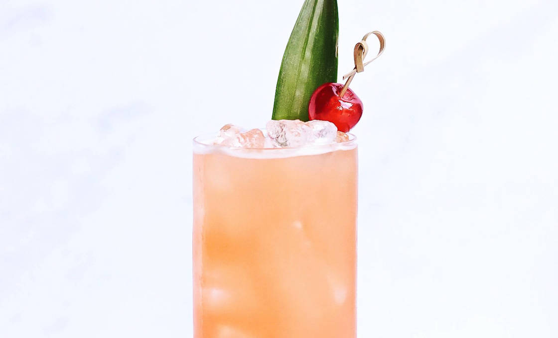 Glass of cherry paradise sitting on a marble counter