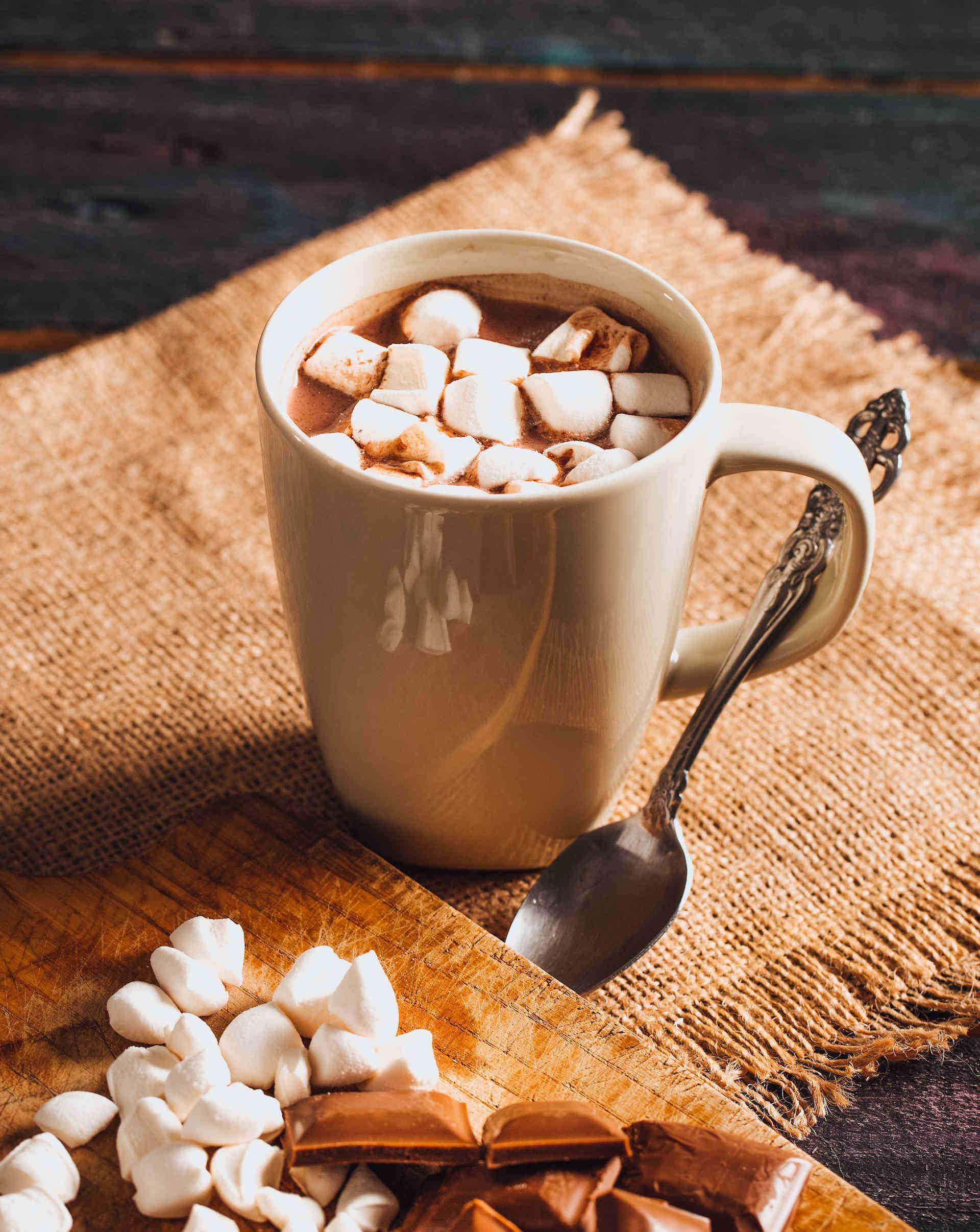 Hot Chocolate on Rustic Table with marshmallows and chocolate squares