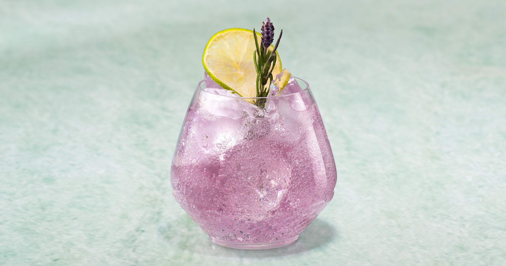 Glass of Lavendar Sonic on a green stone surface