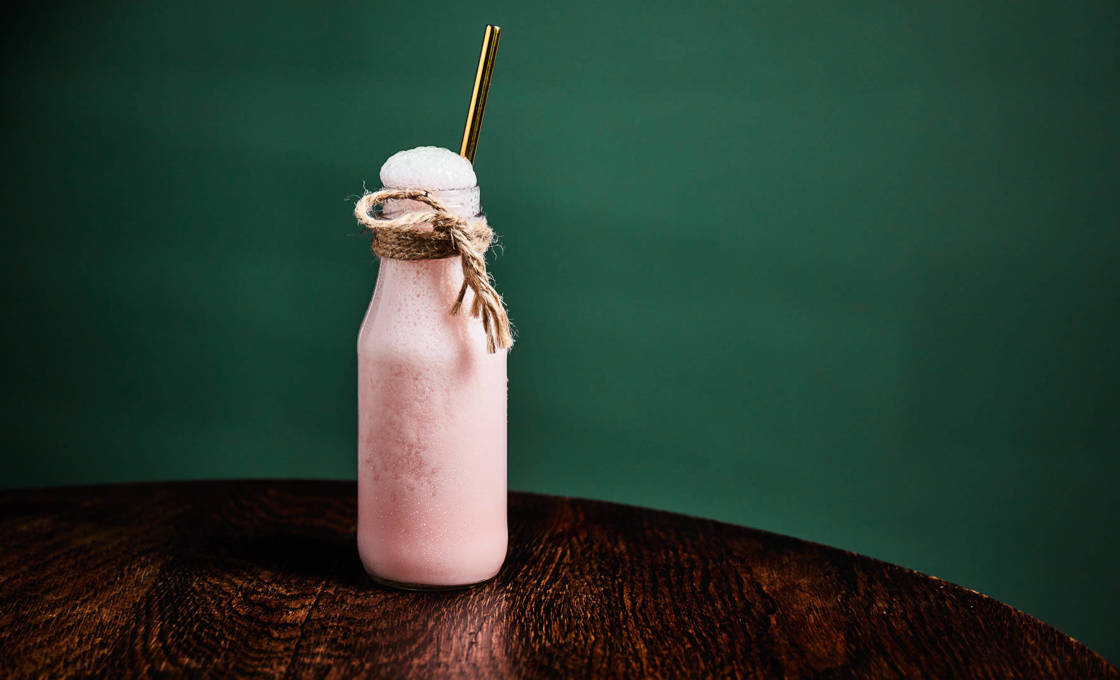 Fruity Bubble Milk on a wooden table against a green wall