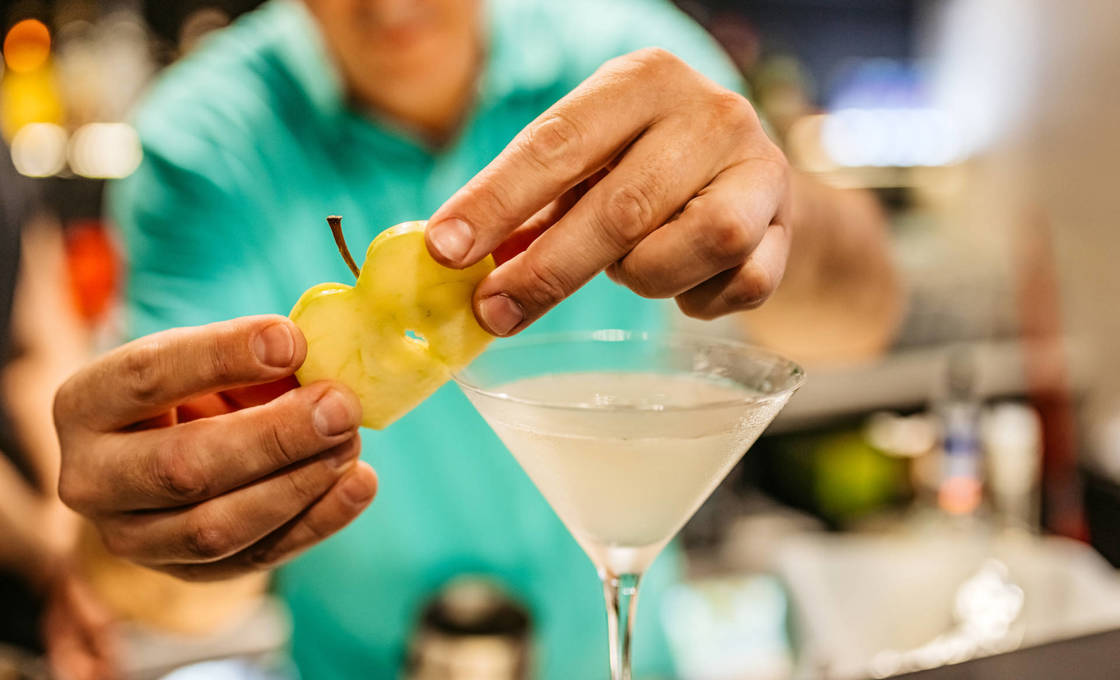 Bartender garnishing a Green Apple Margarita