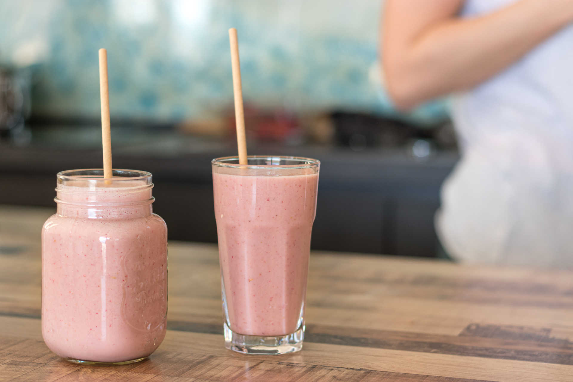 Two glasses of Candy Apple Shake with a woman in the background