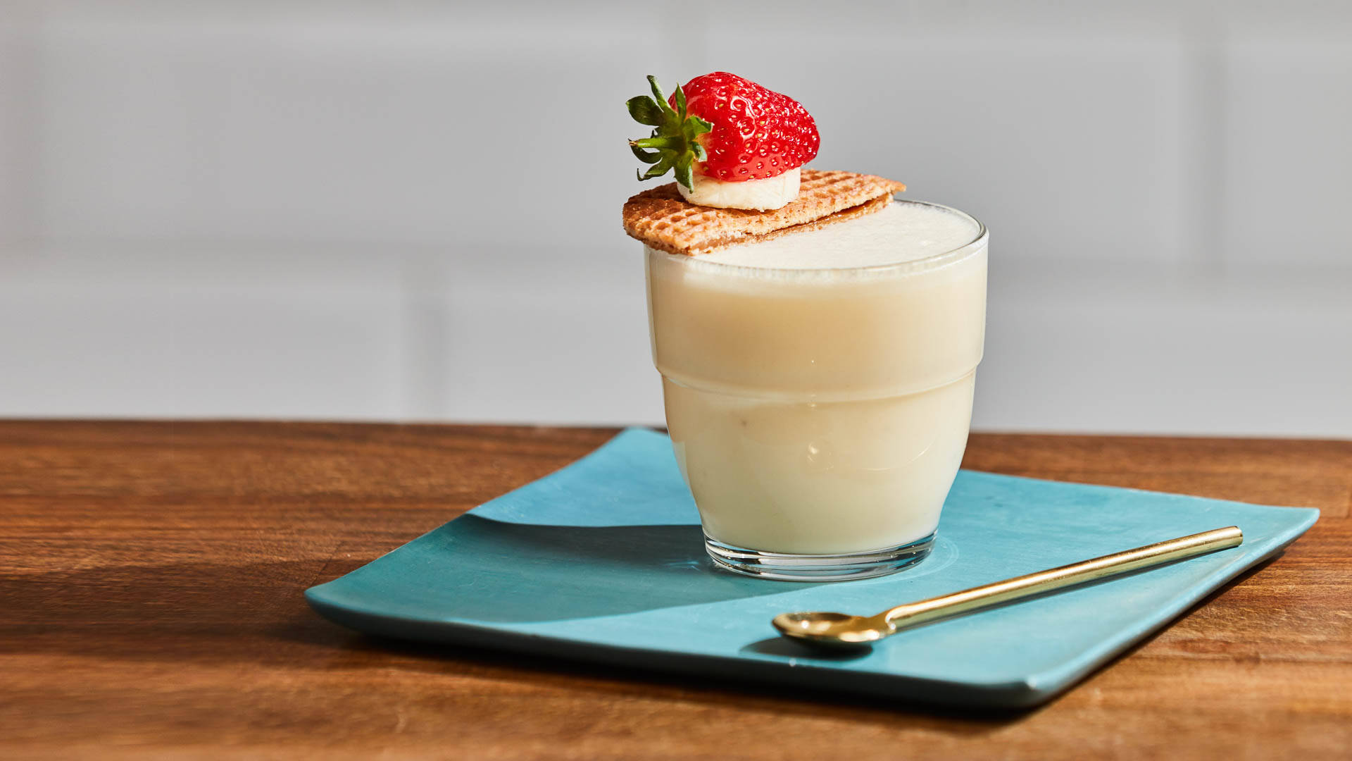Glass of Honey Bee Frappe on a saucer with spoon