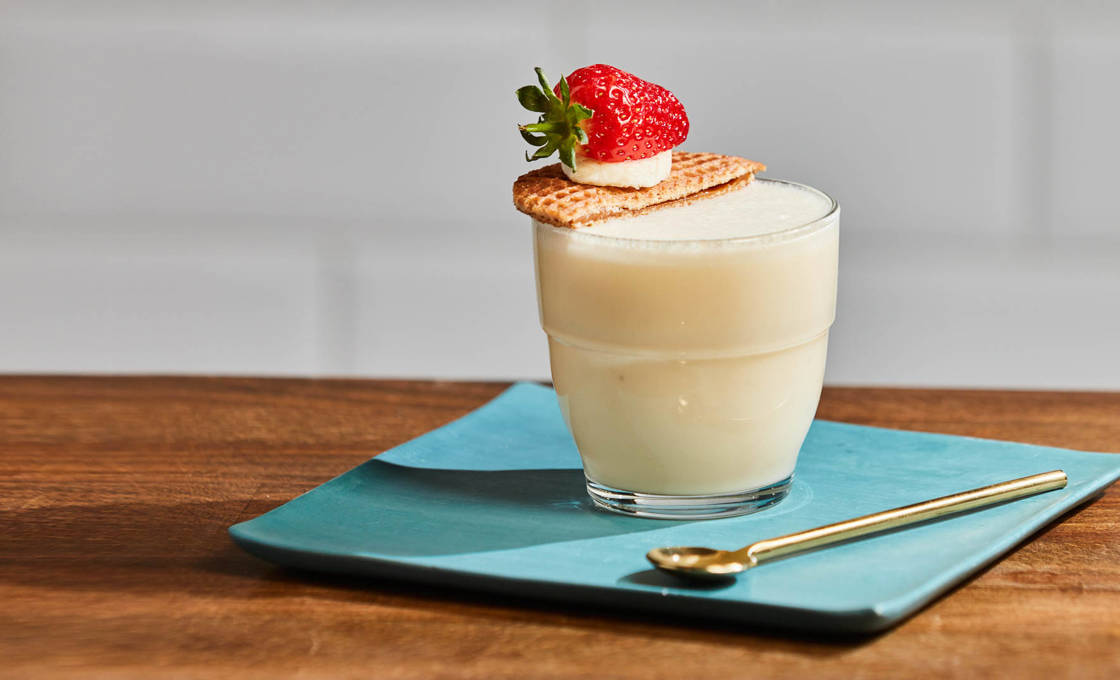Glass of Honey Bee Frappe on a saucer with spoon