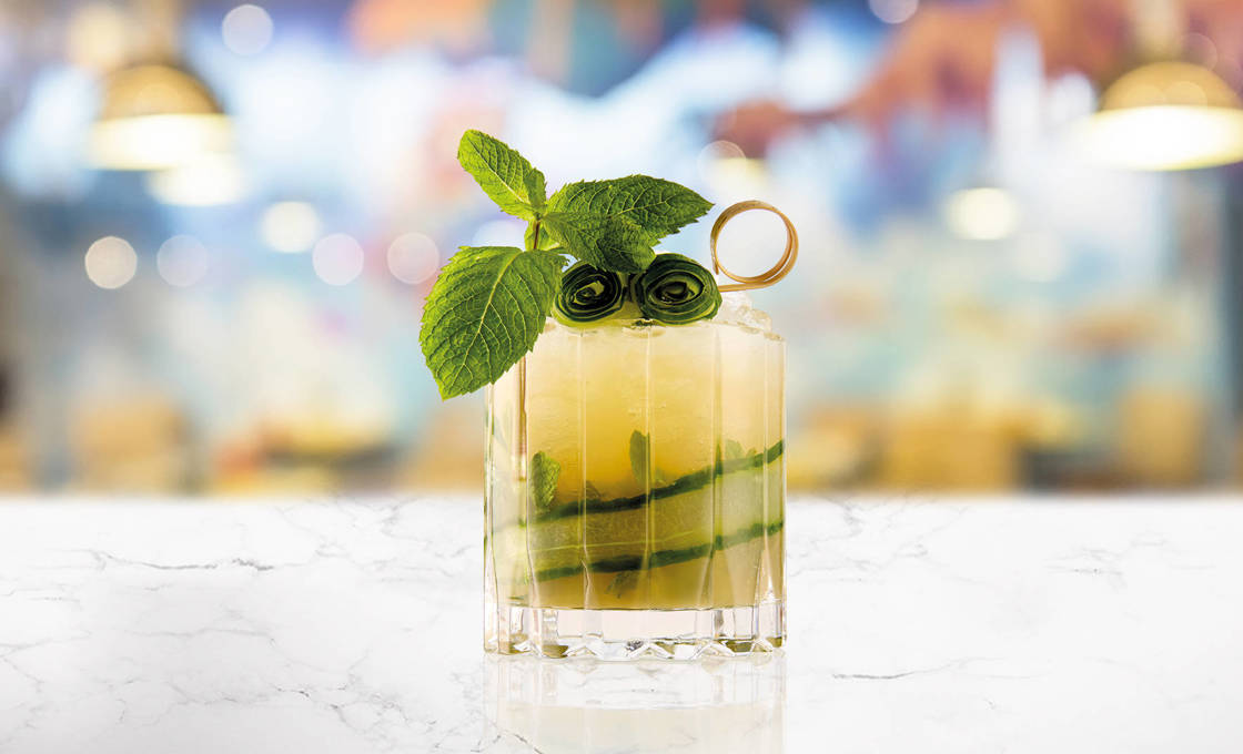 Glass of Green Tea & Cucumber Fizz on a marble surface