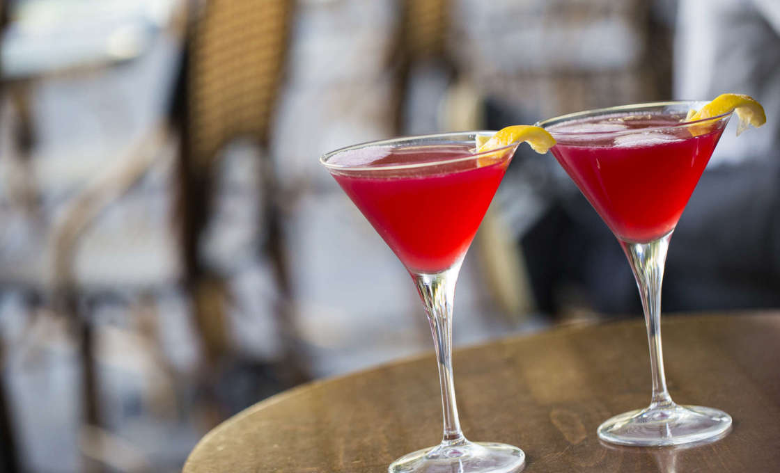 Two glasses of Melon Me on a circular wooden table