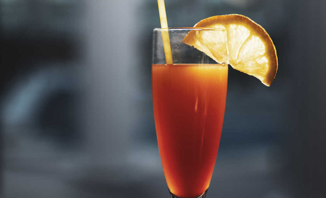 Grenadine Fruit Fizz in a slim glass on a metal table