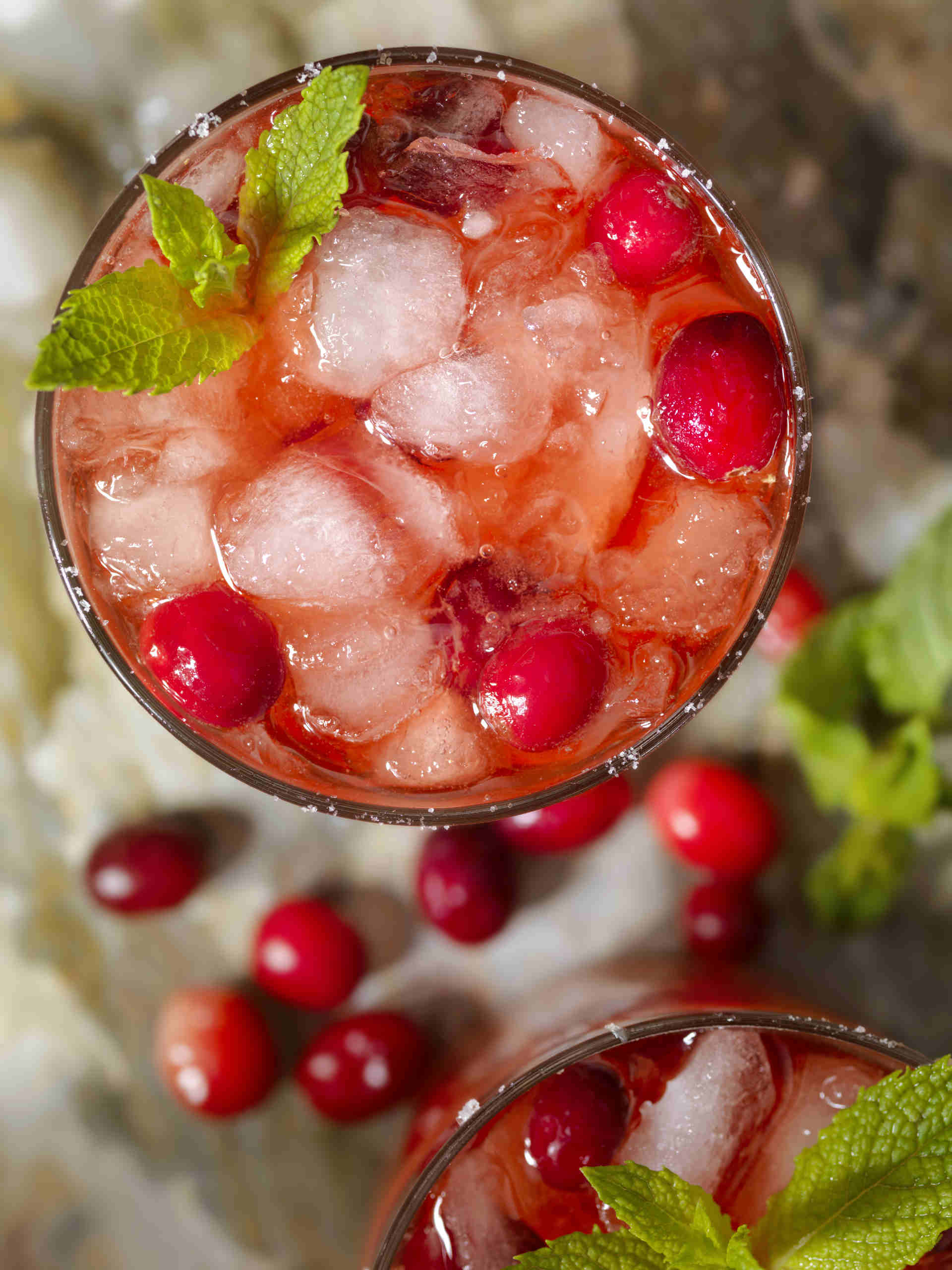 Top down view of a glass of cranberry refresher with loose cranberries