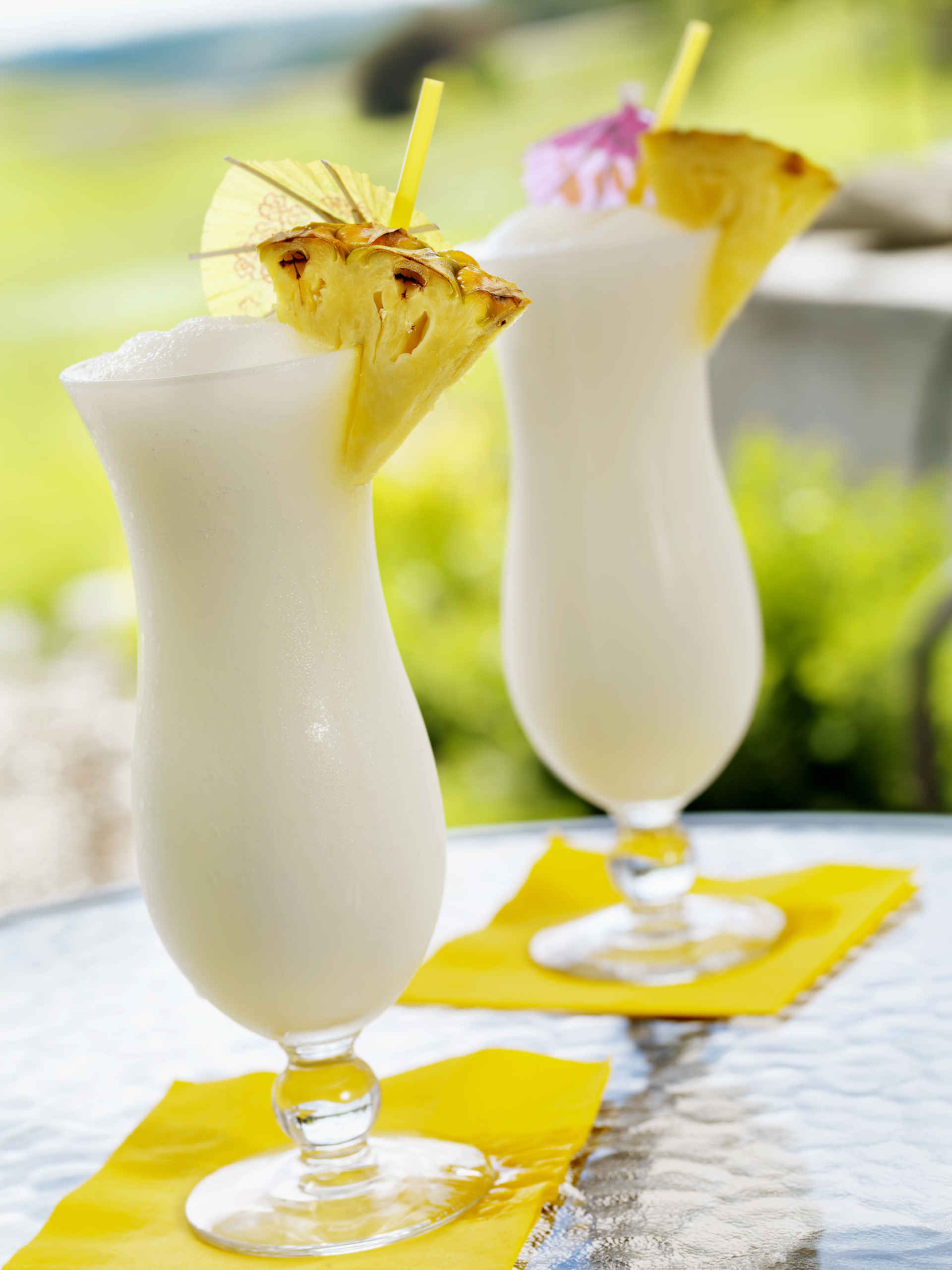 Two glasses of Pina Colada Shake on a glass table outside