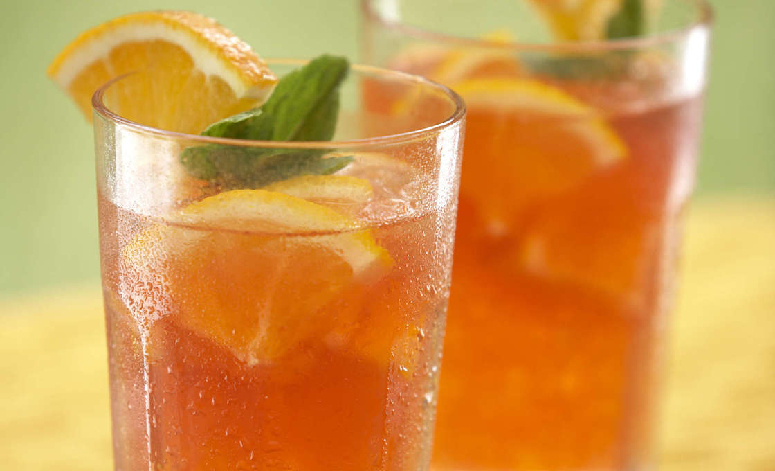 Two glasses of melon tea with a blurred out green background