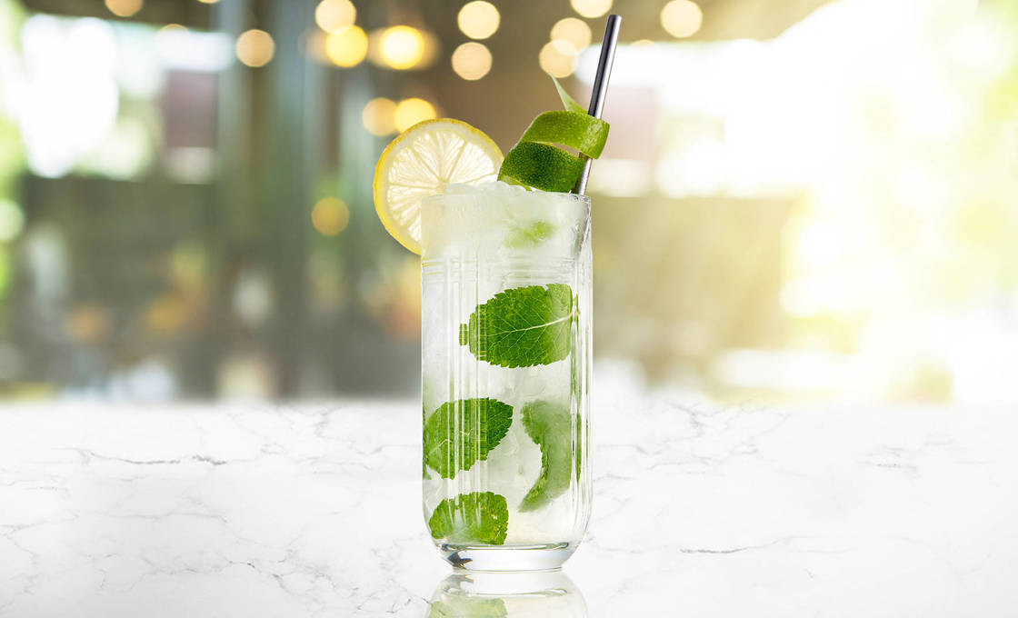 Glass of Yuzu And Coconut Mojito on a marble surface